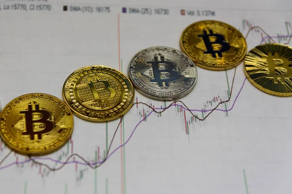 Altın bitcoins kağıt grafik üzerinde yalan