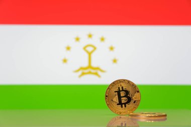  Altın bitcoin Tacikistan Devlet bayrağı bulanık bir arka plan üzerinde duruyor