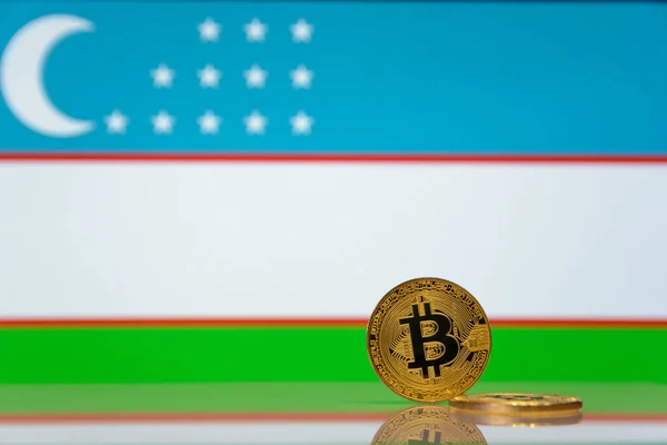  Altın bitcoin Özbekistan devlet bayrağı bulanık bir arka plan üzerinde duruyor