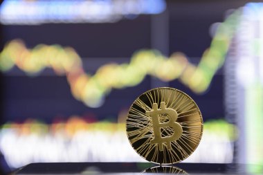 Altın bitcoin ve grafik monitör