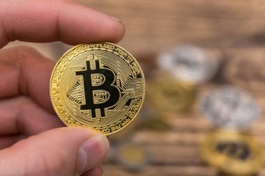  Adamın parmakları eski ahşap arka plan üzerinde tutan bitcoin