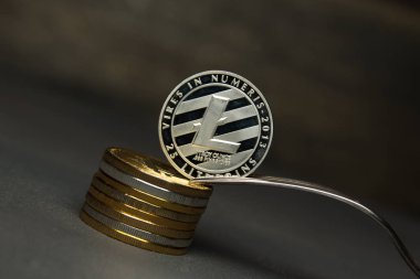 Gümüş litecoin sikke ve gümüş çatal yığını üzerinde durmak