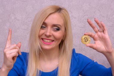 güzel bir sarışın kızın elinde altın bitcoin 