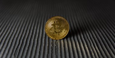  Çizgili arka planda altın bitcoin duruşu