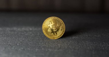  Çizgili arka planda altın bitcoin duruşu