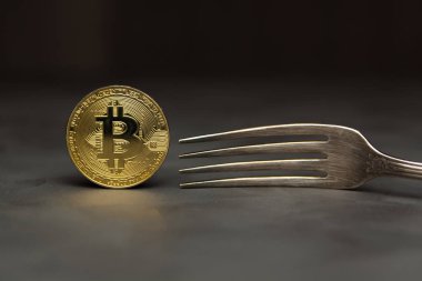  Altın bitcoin gümüş çatal ile drk arka plan üzerinde durmak