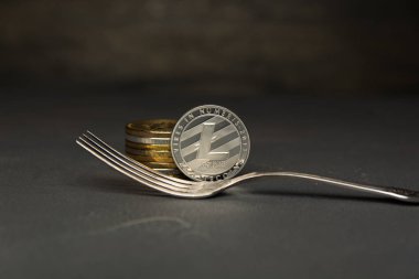 Gümüş Litecoin ve sikke yığını yanında gümüş çatal