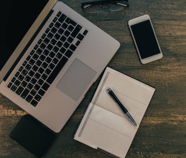 Metin kopyalama yeri olan eski bronz arka plan üzerinde tablo ya da dizüstü bilgisayar, boş defter, kalem ve akıllı telefon Danışma üstten görünüm.