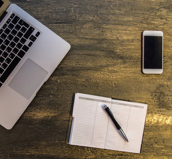 Metin kopyalama yeri olan eski bronz arka plan üzerinde tablo ya da dizüstü bilgisayar, boş defter, kalem ve akıllı telefon Danışma üstten görünüm.
