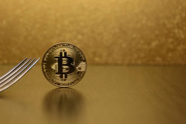  Gümüş çatal ile altın bitcoin üzerinde ahşap masa standı