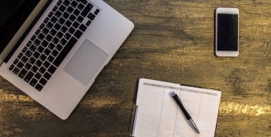 Metin kopyalama yeri olan eski bronz arka plan üzerinde tablo ya da dizüstü bilgisayar, boş defter, kalem ve akıllı telefon Danışma üstten görünüm.