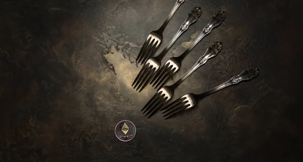 Koyu arka plan üzerinde gümüş çatal ve kripto Döviz Alım Ethereum