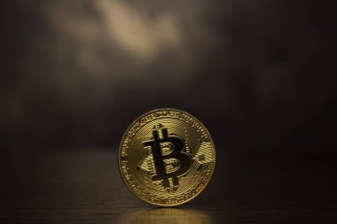  koyu arka plan üzerinde altın bitcoin durmak