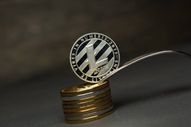 Gümüş litecoin sikke ve gümüş çatal yığını üzerinde durmak