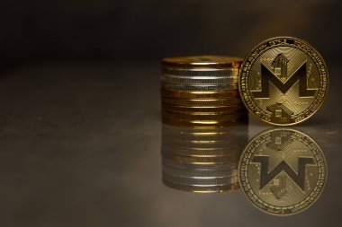  yansıtıcı yüzeyüzerinde altın monero ve sikke yığını
