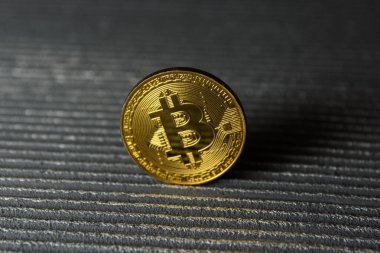  Çizgili arka planda altın bitcoin duruşu