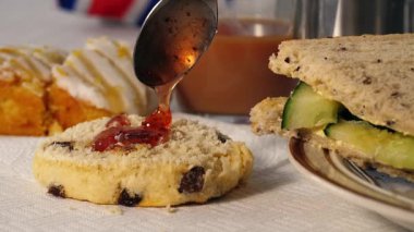 Geleneksel İngiliz çayı reçelli çörek ve salatalıklı sandviç yakın çekim odaklı seçici odaklanma