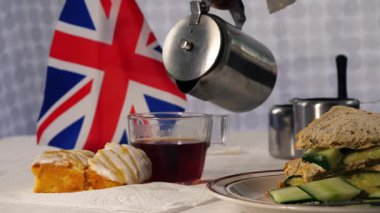 Traditional English tea with cakes and cucumber sandwiches medium 4k shot selective focus