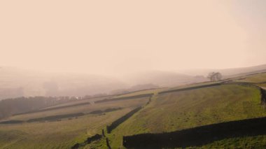 Puslu bir günde Peak District Ulusal Parkı 'ndaki kırsal tarım arazisi geniş zoom insansız hava aracı seçici odak noktası