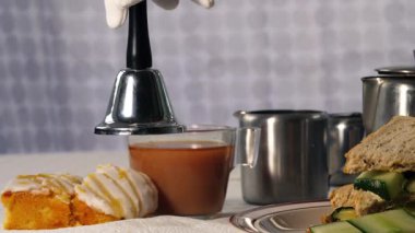 Traditional English cup of tea with cucumber sandwiches and cakes close up zoom shot selective focus