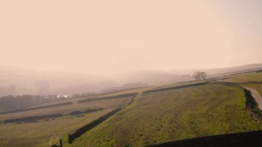 Puslu bir günde Peak District Ulusal Parkı 'ndaki kırsal tarım arazisi 4k hava aracı seçici odak noktası