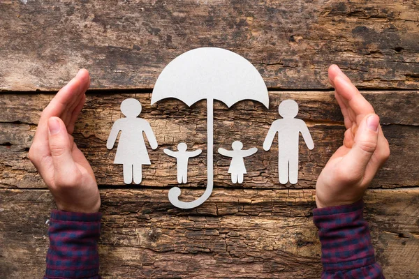 silhouettes of a family under an umbrella concept protection, insurance