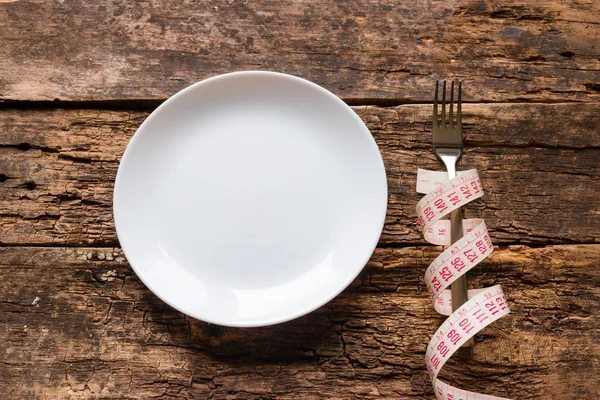 Empty Plate Fork Wrapped Measuring Tape Wooden Background — Stock Photo, Image