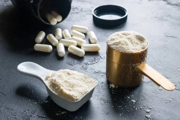 protein ve kreatin yakın çekim siyah bir zemin üzerine iki ölçüm kaşığı