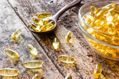 ahşap arka plan yakın çekim üzerinde balık yağı kapsülleri