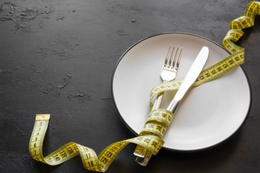 boş levha ve ölçüm bandı diyet sembol siyah bir zemin üzerine metin için yer ile