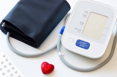 Otomatik tonometer ve beyaz arka plan yakın çekim hapları