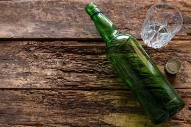 empty bottle and glass on a wooden background concept alcoholism clipart