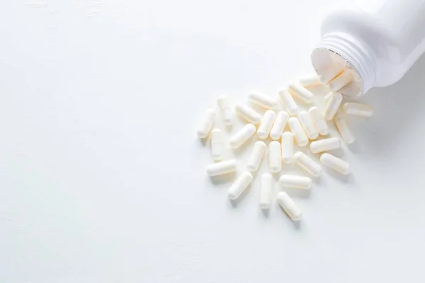 Pillen Die Aus Der Tablettenflasche Auf Weißem Hintergrund Mit Kopierraum — Stockfoto