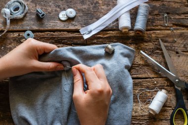 terzi kıyafet ahşap arka plan üzerinde bir düğme diker