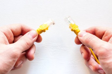 adam sarı ağ internet kablosu tutar