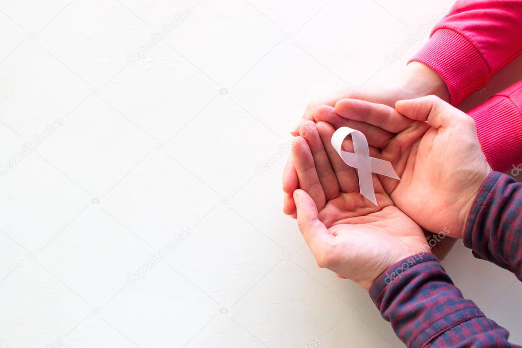 man and woman hold white ribbon