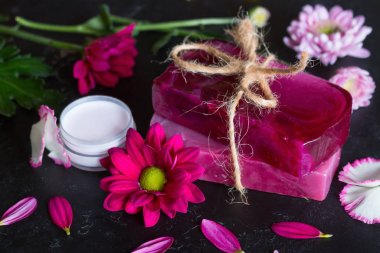 siyah arka plan yakın çekim üzerinde çiçeklerden el yapımı sabun ve krem