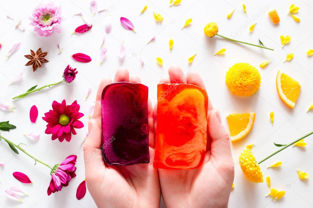 handmade soap in the hands for the spa on the background of fruits and flowers