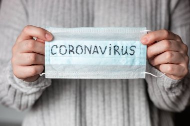 Koronavirüs etiketli bir antiviral maske taşıyor.
