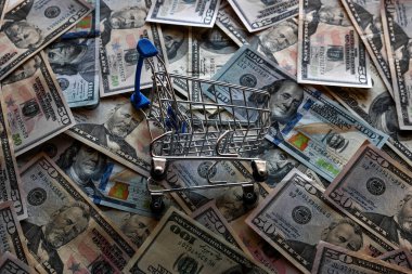Dolar banknotlarının arka planında market arabası, konsept krizi, enflasyon