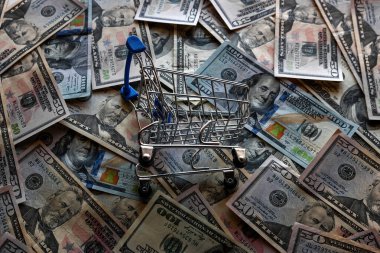 grocery cart on the background of dollar bills, concept crisis, inflation clipart