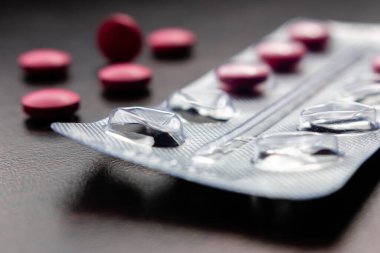 Karanlık arka planda yarım paket boş hap seçici odak kapat