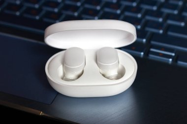 Kablosuz bluetooth kulaklıklar bir dizüstü bilgisayarın arka planında