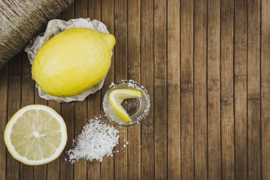 Limon, kadeh tekila ve deniz ahşap masada tuz. Metin için yer kopyalayın