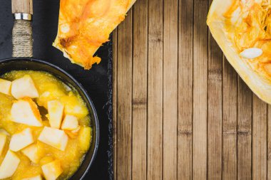 Ahşap bir masa üzerinde bir tavada kabak parçaları. Eve kabak yemek. Metin için yer kopyalayın