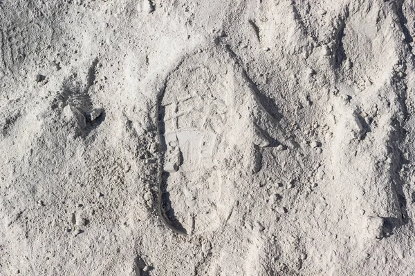 Footprint on white sand or dust. The trail of man on lunar soil or desert.