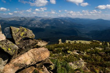 Taşların altında mavi gökyüzü bulutlu. Dağ vadinin görünümü. Turizm, seyahat dağlar.
