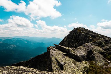 Taşların altında mavi gökyüzü bulutlu. Dağ vadinin görünümü. Turizm, seyahat dağlar.