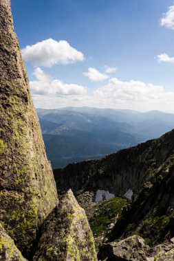 Taşların altında mavi gökyüzü bulutlu. Dağ vadinin görünümü. Turizm, seyahat dağlar.