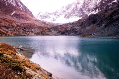 Kışın dağ gölü. Şafak kayalarda. Dağ Vadisi Nehri boyunca seyahat
